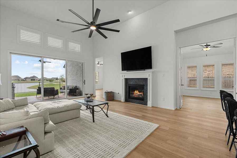Living room showcases soaring ceilings, a cozy fireplace, and breathtaking water views.