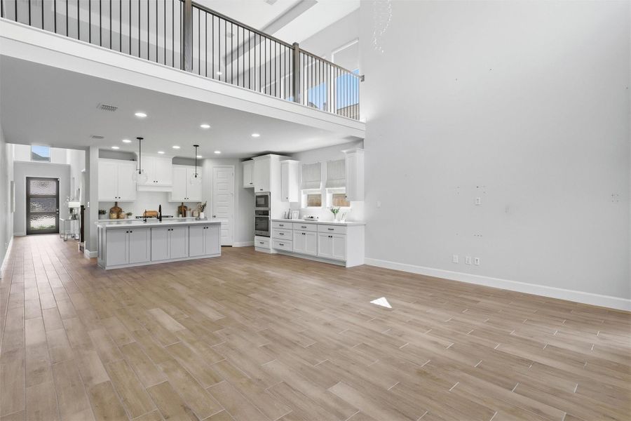 This wide-angle view captures the seamless flow between the family room and gourmet kitchen, highlighting the home's open-concept design, soaring ceilings, and exceptional sense of space that make entertaining effortless.