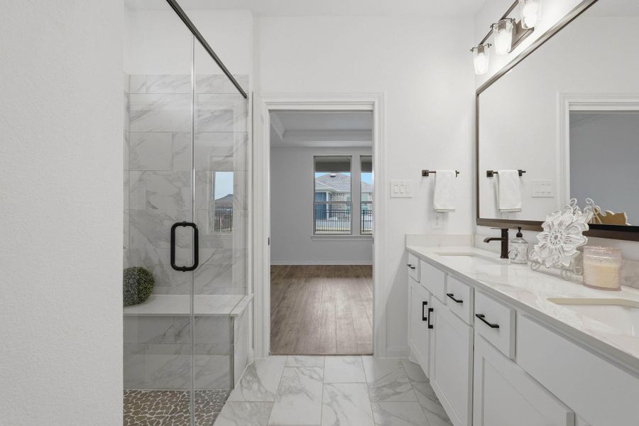 Light-filled and modern, this bathroom flows beautifully with sleek cabinetry, a spacious shower, and thoughtful design details throughout.