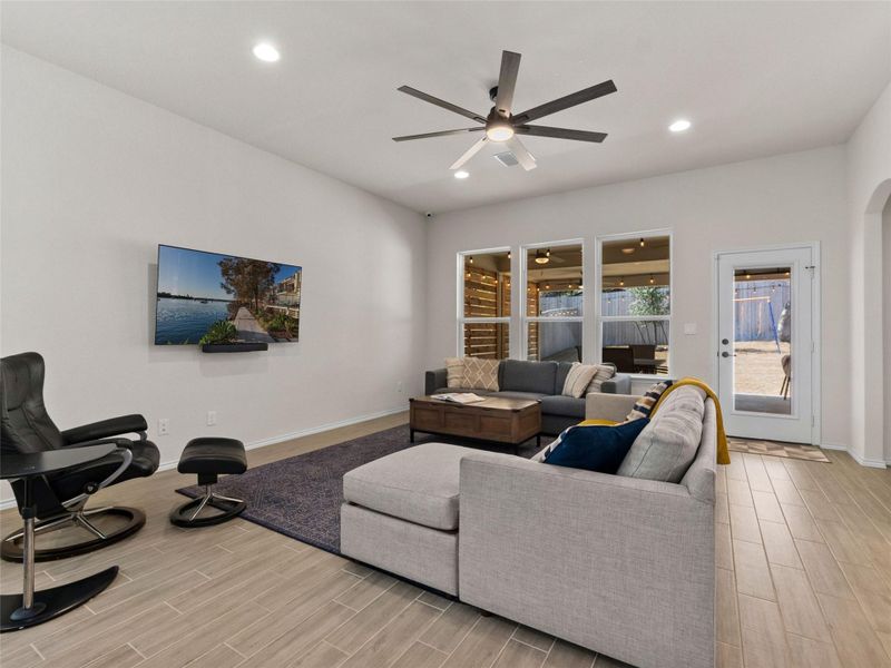 Living room featuring wood tiled floors, arched walkways, a ceiling fan, and recessed lighting