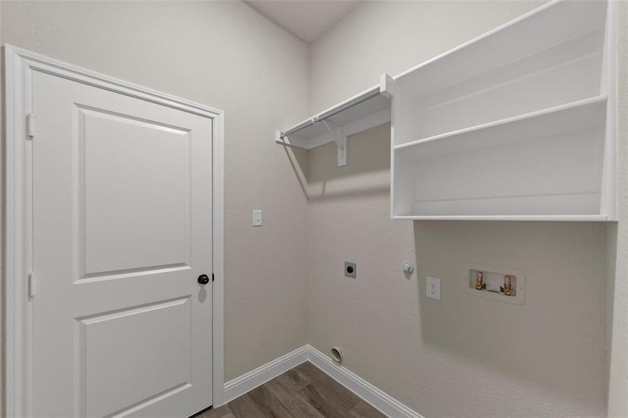 Dedicated utility area featuring wood-finish flooring