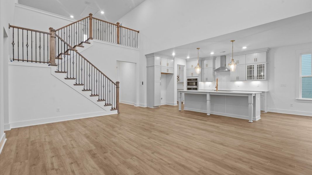 Spacious and stylish family room with two-story ceilings that create a bright and open atmosphere