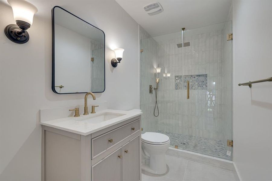 Bathroom featuring tile patterned flooring, an enclosed shower, toilet, and vanity