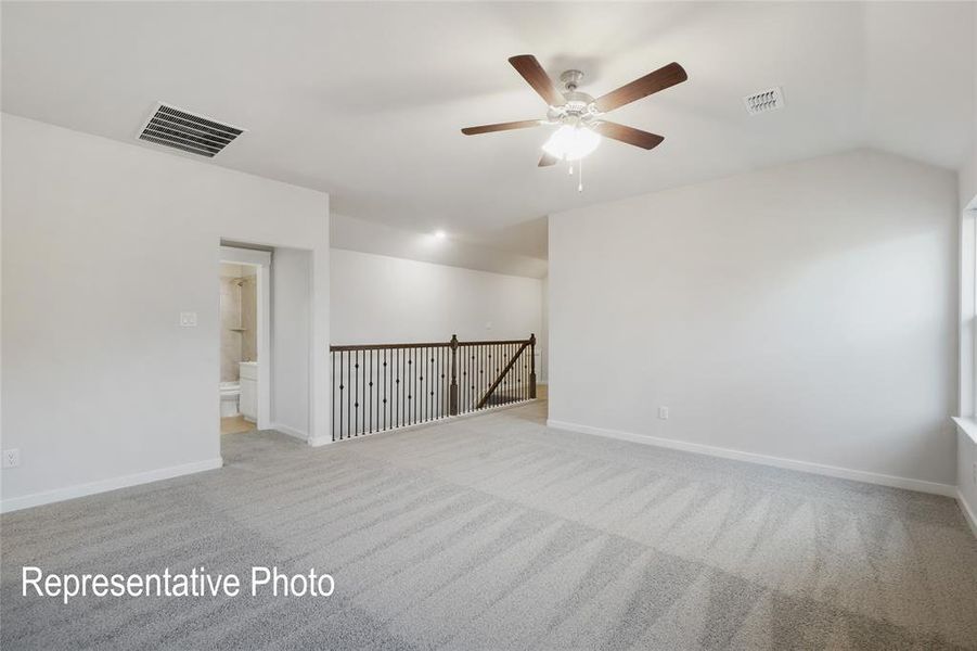 Carpeted empty room with ceiling fan and vaulted ceiling