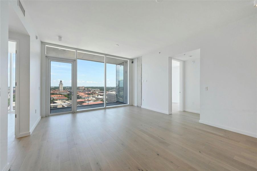 Expansive living space with wide-plank oak flooring, floor-to-ceiling windows, and uninterrupted views of the UT Tower and city skyline. Step onto your private balcony and take in the best of downtown Austin living.