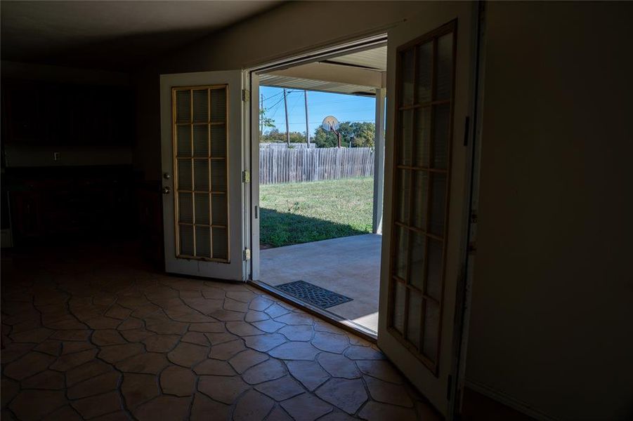 Doorway to outside featuring french doors and stone finish floors