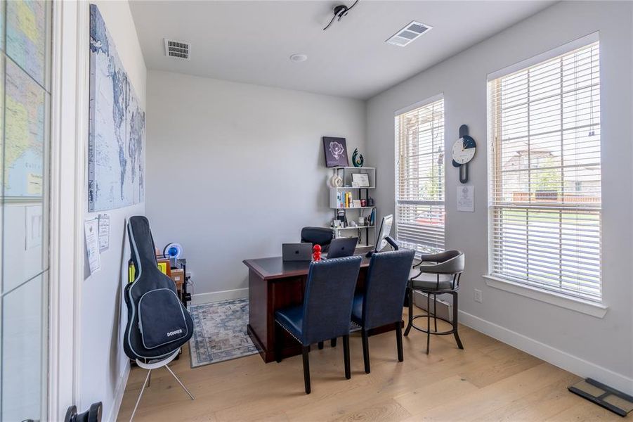 Office area with light wood-style flooring and baseboards