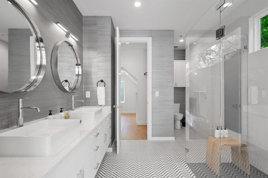 Duel vanities, custom wall finishes, and a zero-threshold walk-in shower.