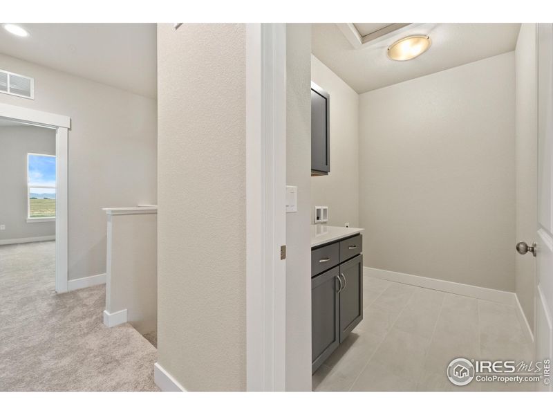 Upstairs laundry room with built-in cabinets.