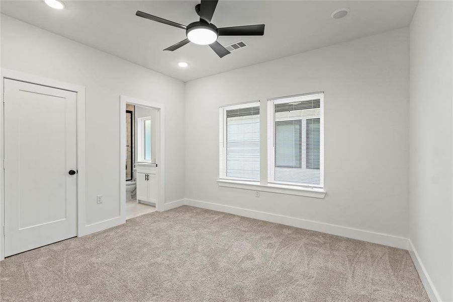 Unfurnished bedroom featuring light colored carpet, ensuite bathroom, a ceiling fan, and recessed lighting Unfurnished bedroom featuring light colored carpet, ensuite bathroom, a ceiling fan, and recessed lighting
