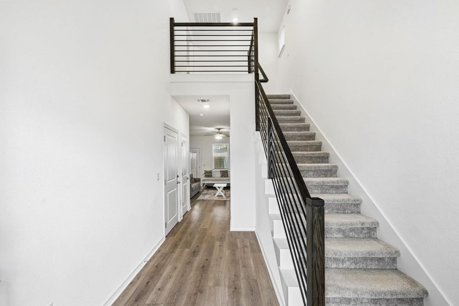 Staircase featuring a high ceiling and wood finished floors