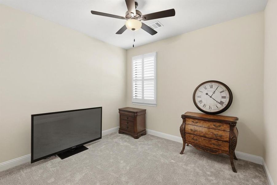 Living area with light carpet and ceiling fan