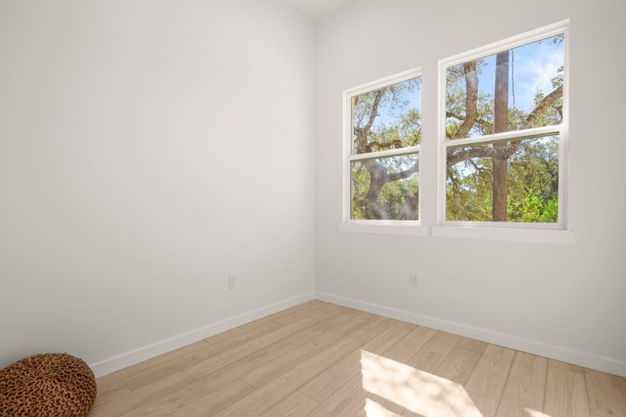 Empty room with baseboards and light wood-type flooring