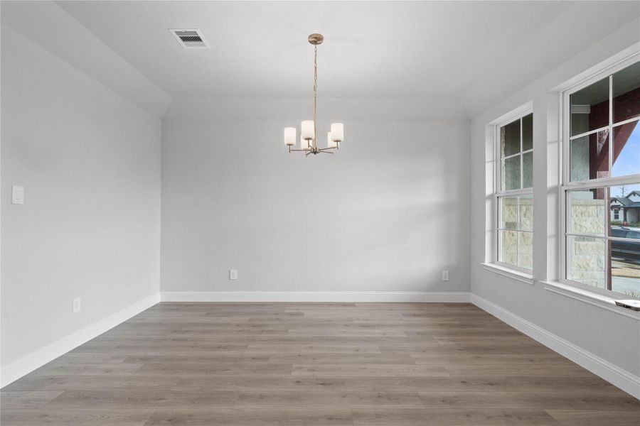 You and your guests will certainly dine in style in this amazing formal dining room! Featuring a gorgeous modern chandelier, large windows, neutral paint, high ceilings, and durable laminate flooring! Perfect space to entertain family and friends!