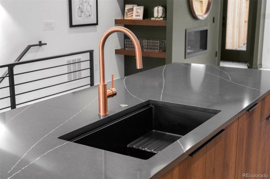 Copper fixtures pop with dark granite counters