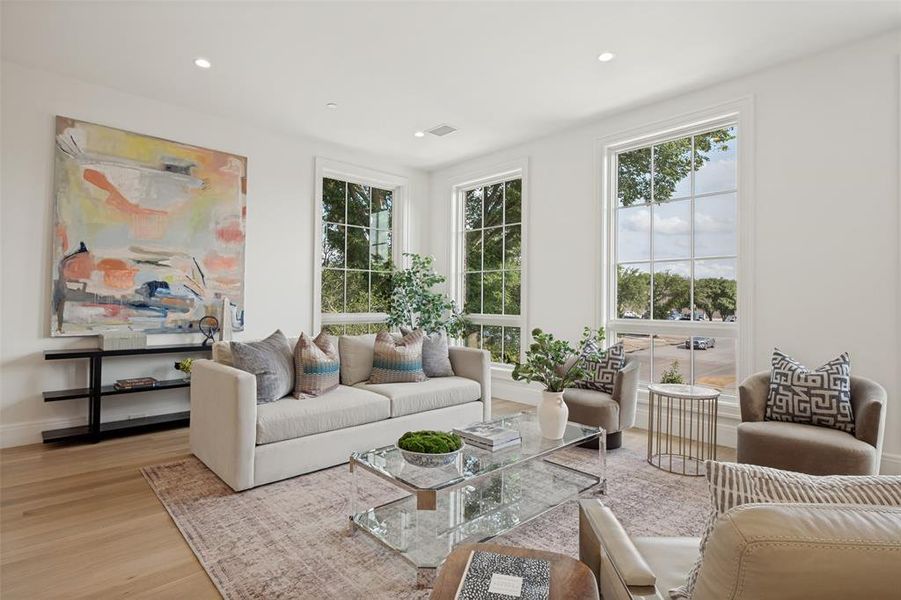 Spacious living area featuring beautiful wide-plank flooring and abundant natural light, perfect for relaxing or entertaining guests. Spacious living area featuring beautiful wide-plank flooring and abundant natural light, perfect for relaxing or entertaining guests.