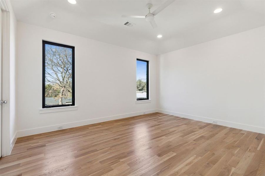 Secondary bedroom featuring light wood and a ceiling fan