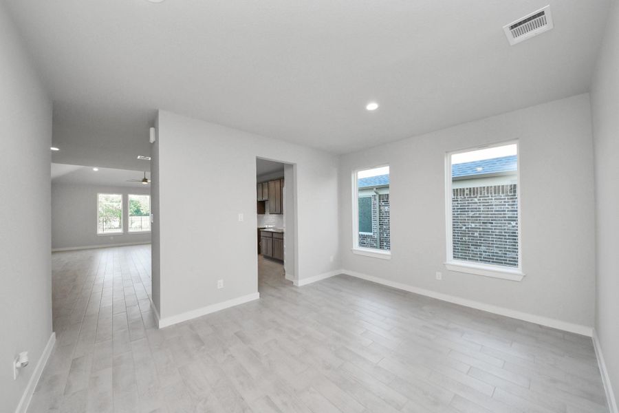 Make memories gathered around the table with your family and friends! This spacious dining room features elegant flooring, custom paint, and adjacent to family room and kitchen for open concept feel. Sample photo of completed home with similar floor plan. Actual colors and selections may vary.