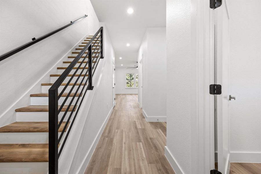 Staircase featuring wood finished floors and recessed lighting
