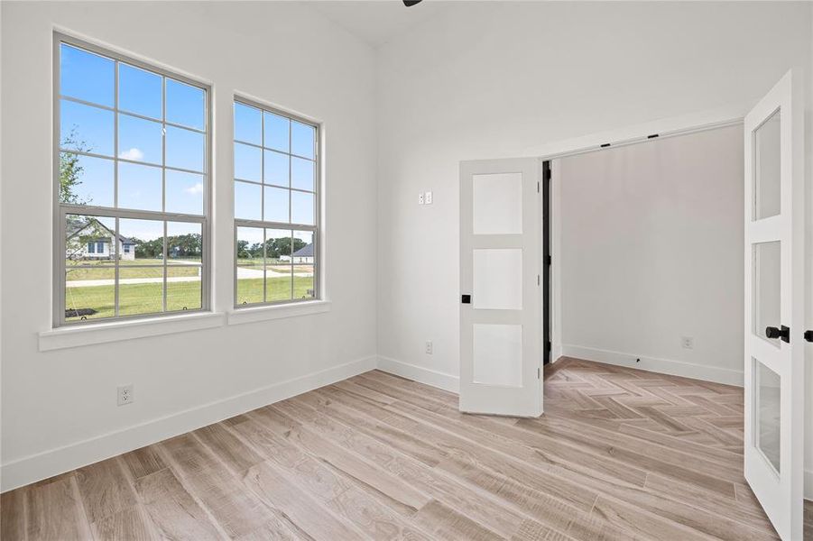 Unfurnished room with light wood finished floors and french doors Unfurnished room with light wood finished floors and french doors