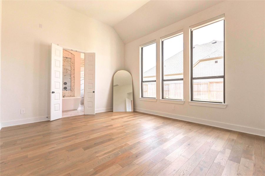 This spacious, bright room features large windows, hardwood floors, and a vaulted ceiling. It connects to a bathroom with double doors, adding convenience and elegance. This spacious, bright room features large windows, hardwood floors, and a vaulted ceiling. It connects to a bathroom with double doors, adding convenience and elegance.