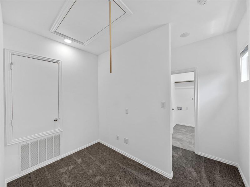 Unfurnished room featuring dark colored carpet