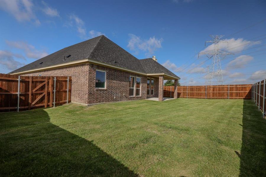 Rear view of house featuring roof with shingles, brick siding, a fenced backyard, and a chimney Rear view of house featuring roof with shingles, brick siding, a fenced backyard, and a chimney