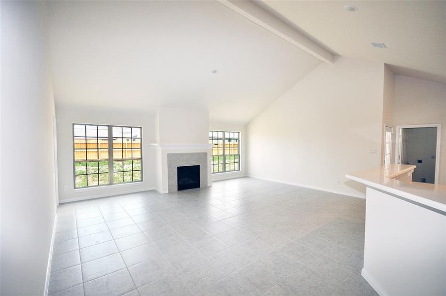 The fireplace is flanked by and expanse of natural lighting through 2 large windows.