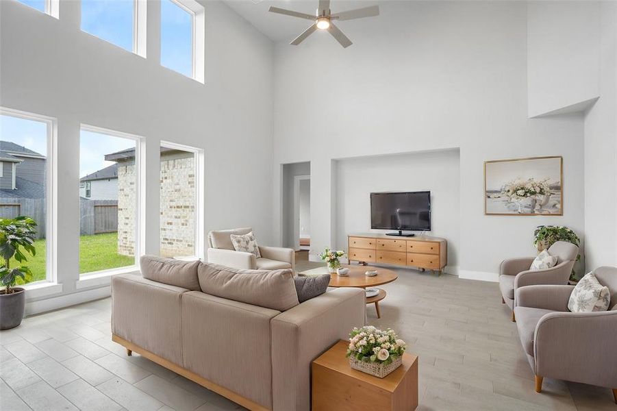 Gather the family and guests together in your lovely living room! Featuring soaring high ceilings, recessed lighting, ceiling fan, custom paint, gorgeous floors, and large windows that provide plenty of natural lighting throughout the day.