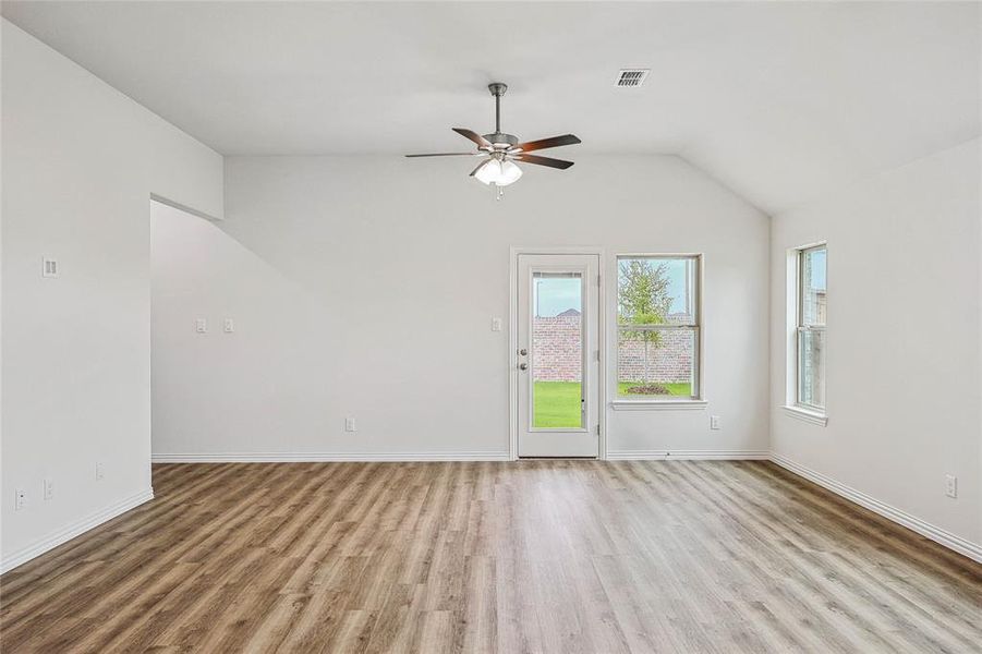 Spare room with vaulted ceiling, hardwood / wood-style floors, and ceiling fan