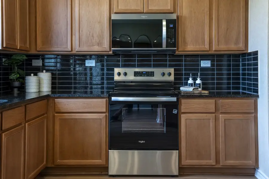 Granite countertops with glossy stacked tile backsplash