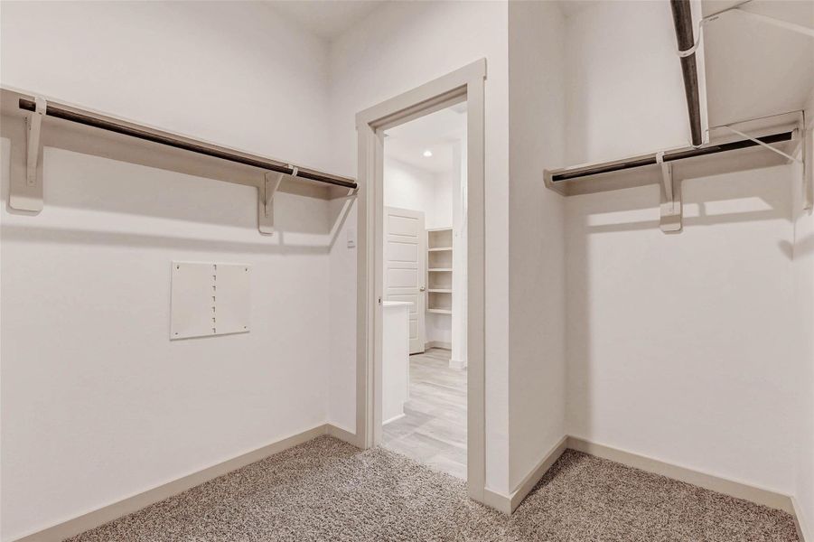 This spacious walk-in closet offers ample hanging space, built-in storage, and plush carpet underfoot. With easy access from the primary bath, it’s the perfect setup for keeping wardrobes neat, organized, and out of sight. This spacious walk-in closet offers ample hanging space, built-in storage, and plush carpet underfoot. With easy access from the primary bath, it’s the perfect setup for keeping wardrobes neat, organized, and out of sight.