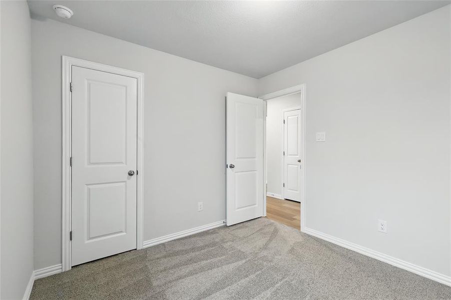 Unfurnished bedroom featuring carpet floors and baseboards