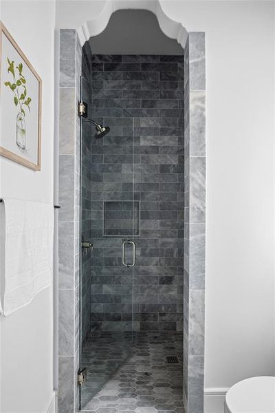 Bathroom with a shower stall and toilet