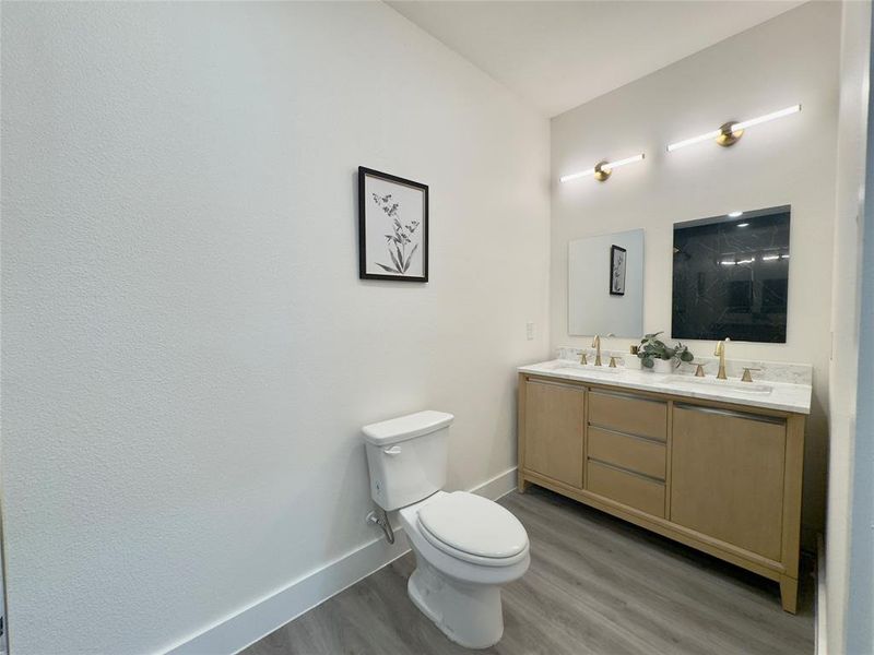 Bathroom with vanity, toilet, and hardwood / wood-style flooring