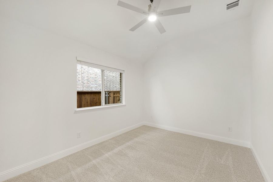Empty bedroom with vaulted ceiling, ceiling fan, carpet flooring, and single window