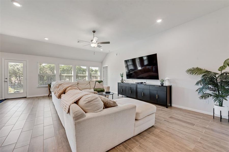 Living area featuring lofted ceiling, recessed lighting, wood tiled floors, and ceiling fan Living area featuring lofted ceiling, recessed lighting, wood tiled floors, and ceiling fan