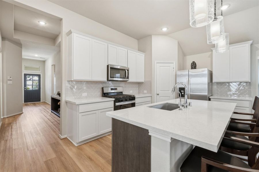 This modern kitchen features sleek white cabinetry, stainless steel appliances, and a large island with seating. The open layout and light wood flooring create a bright, inviting space perfect for cooking and entertaining. This modern kitchen features sleek white cabinetry, stainless steel appliances, and a large island with seating. The open layout and light wood flooring create a bright, inviting space perfect for cooking and entertaining.