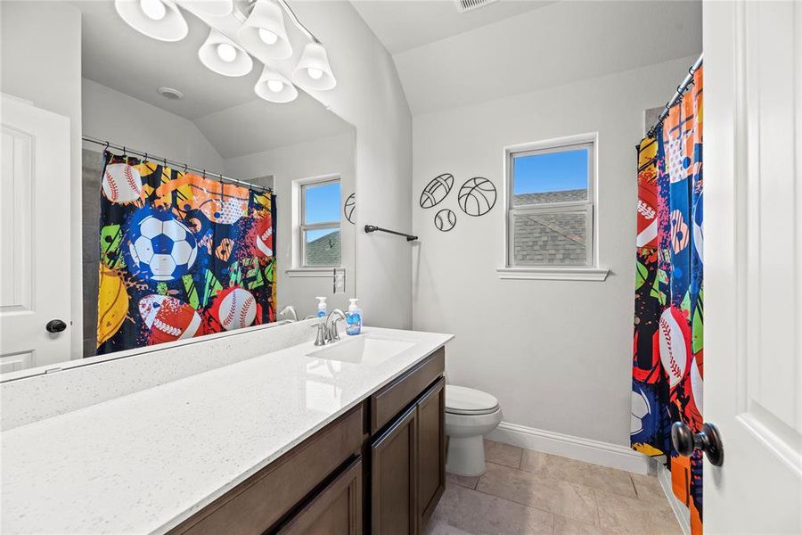 This is a bright restroom features a double vanity with ample counter space and a window for natural light.