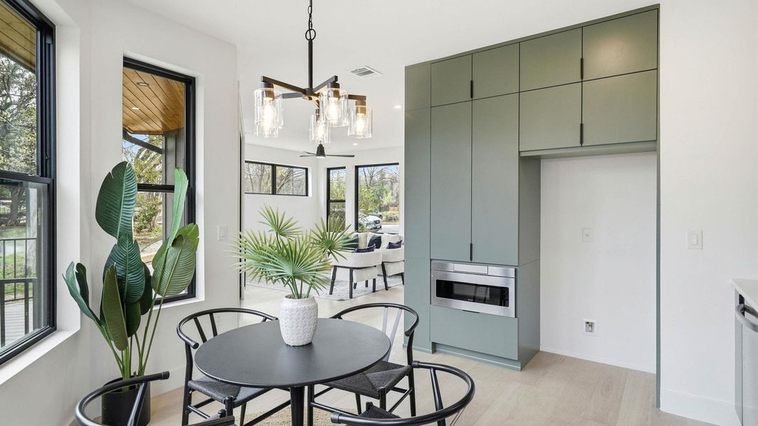 Dining space with light wood-style flooring and hanging lights