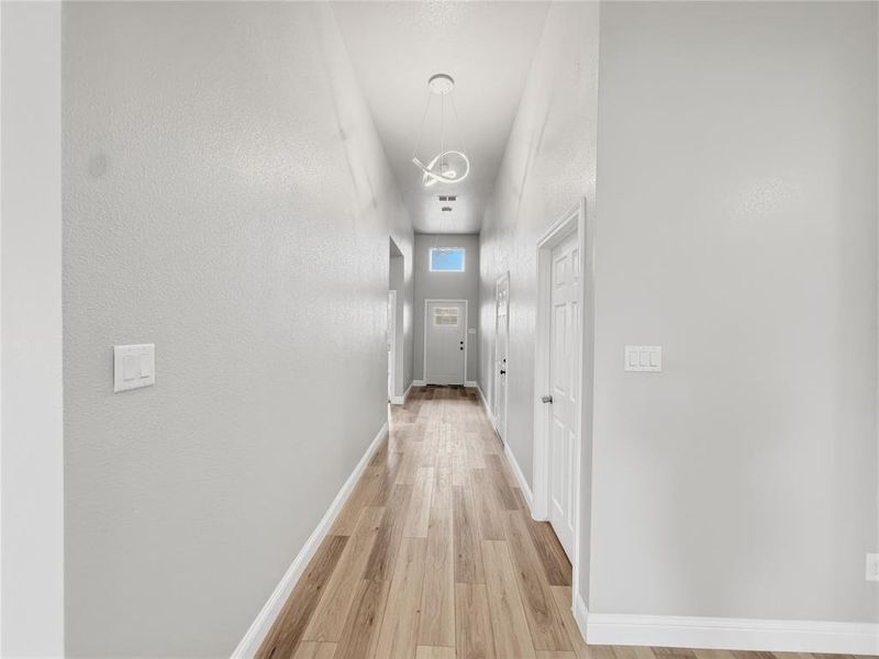 Hallway with baseboards and light wood-type flooring