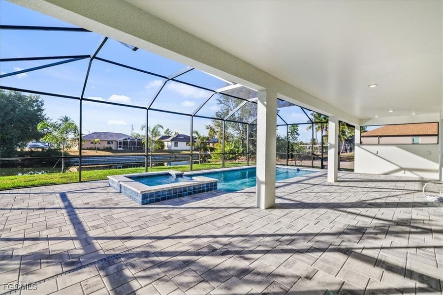 View of swimming pool with a patio, a sunroom, a pool with connected hot tub, and a lanai