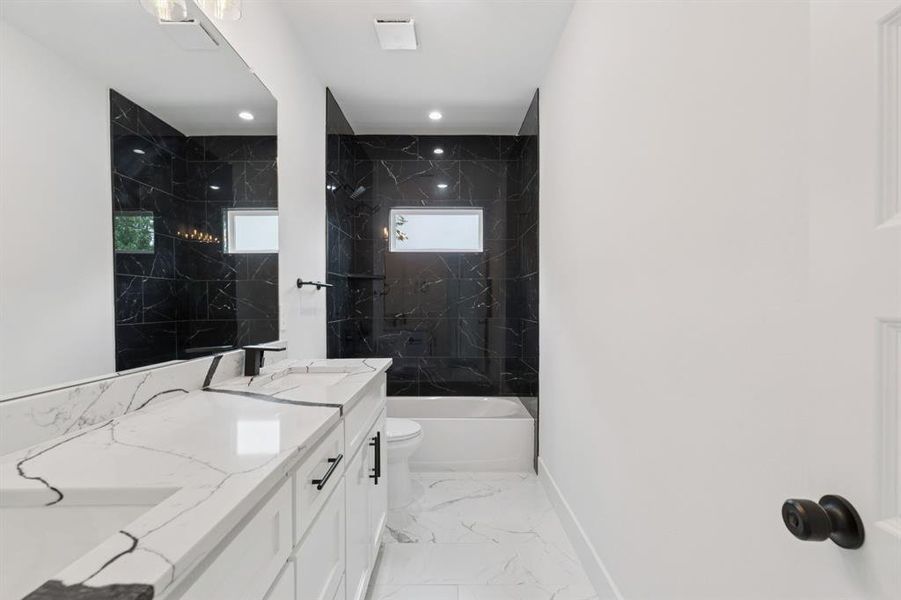 Bathroom featuring a combined bath / shower with marble appearance, double vanity, light marble finish flooring, and recessed lighting Bathroom featuring a combined bath / shower with marble appearance, double vanity, light marble finish flooring, and recessed lighting