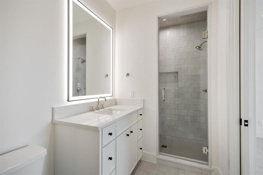 Bathroom with vanity, a stall shower, and light tile patterned flooring Bathroom with vanity, a stall shower, and light tile patterned flooring