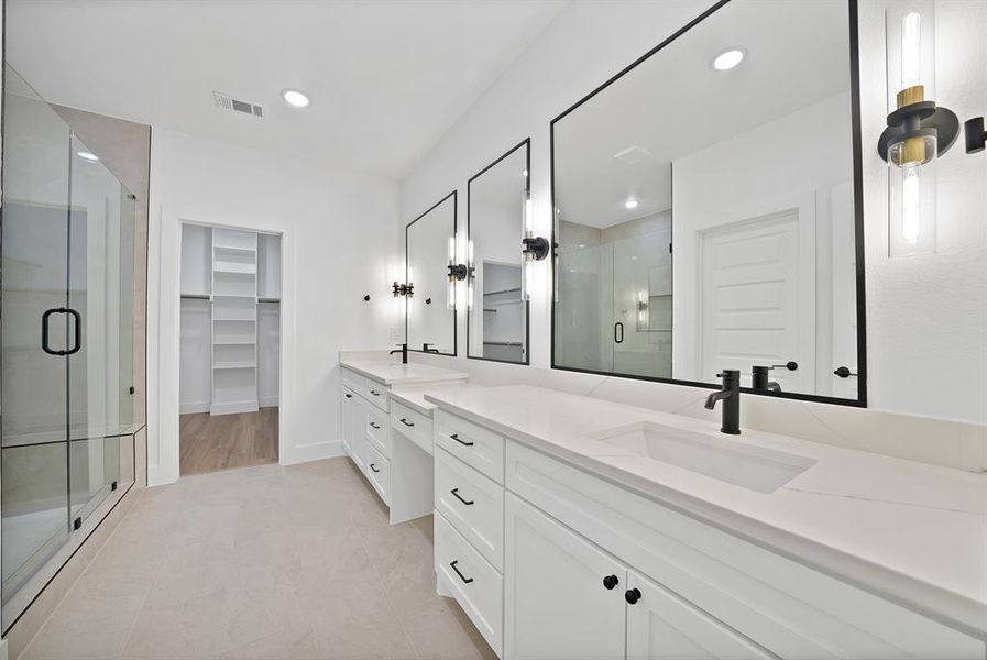 Bathroom featuring a dual vanity with white cabinetry, integrated sinks, and matte black fixtures Bathroom featuring a dual vanity with white cabinetry, integrated sinks, and matte black fixtures