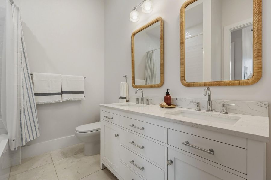 Double sink ensuite with honed marble flooring