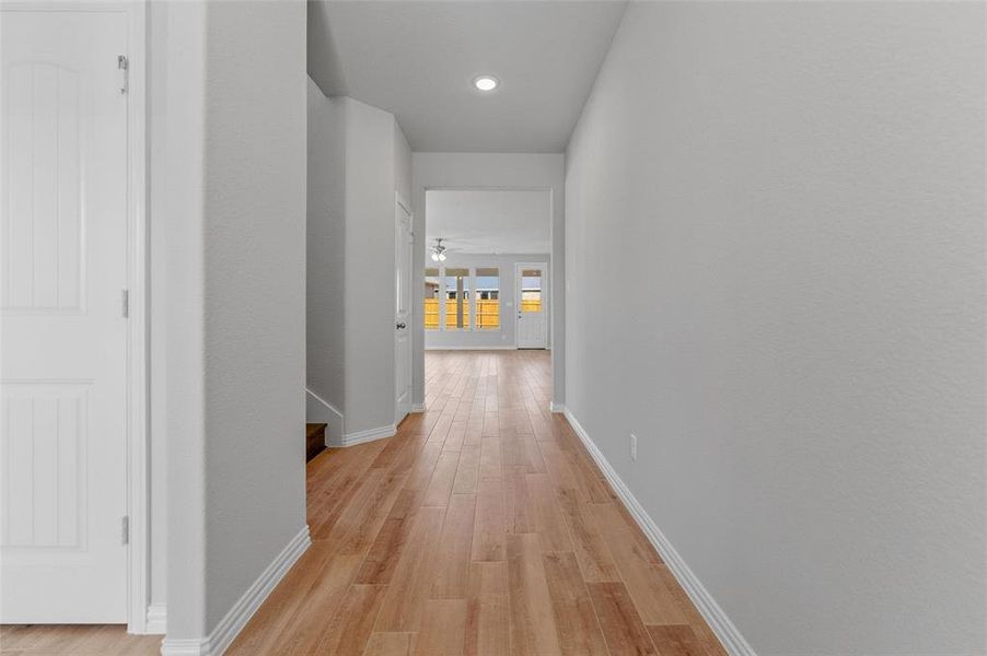 Hall with light wood-type flooring and baseboards