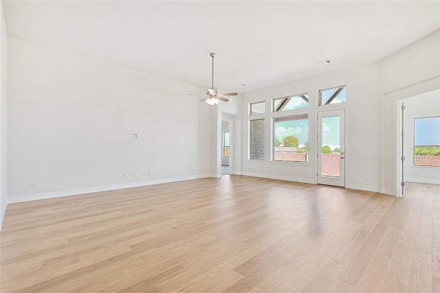 Unfurnished living room with ceiling fan and light wood-type flooring