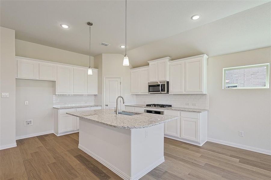 Kitchen featuring white cabinetry, stainless steel appliances, sink, and light wood-type flooring