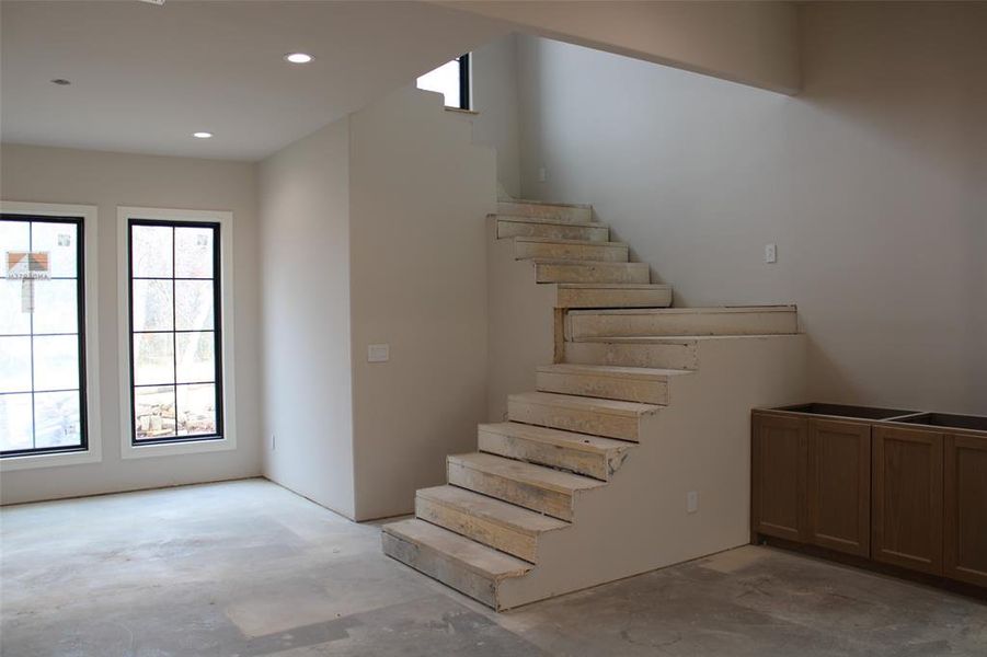 Stairway with a healthy amount of sunlight and concrete floors